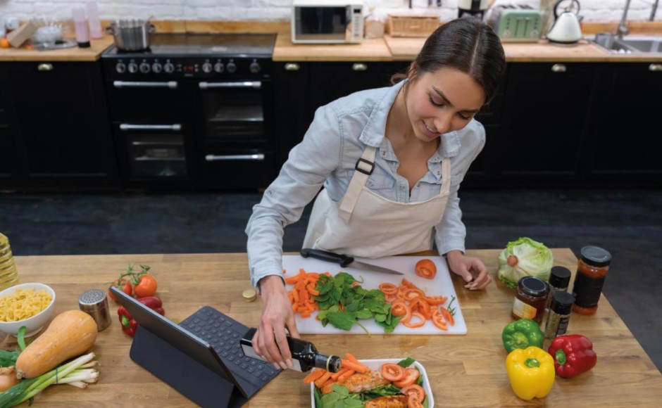 Mujer preparando ensalada viendo curso en línea