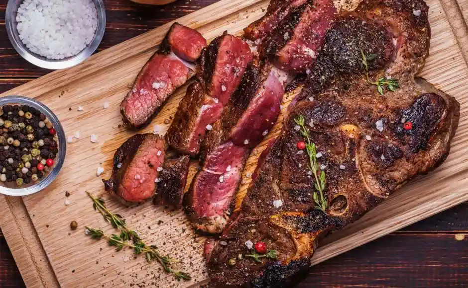 lonjas de carne cocida, condimentada sobre una tabla de madera