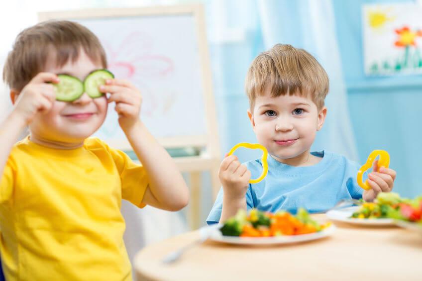 Niños comiendo verduras y jugando con ellas