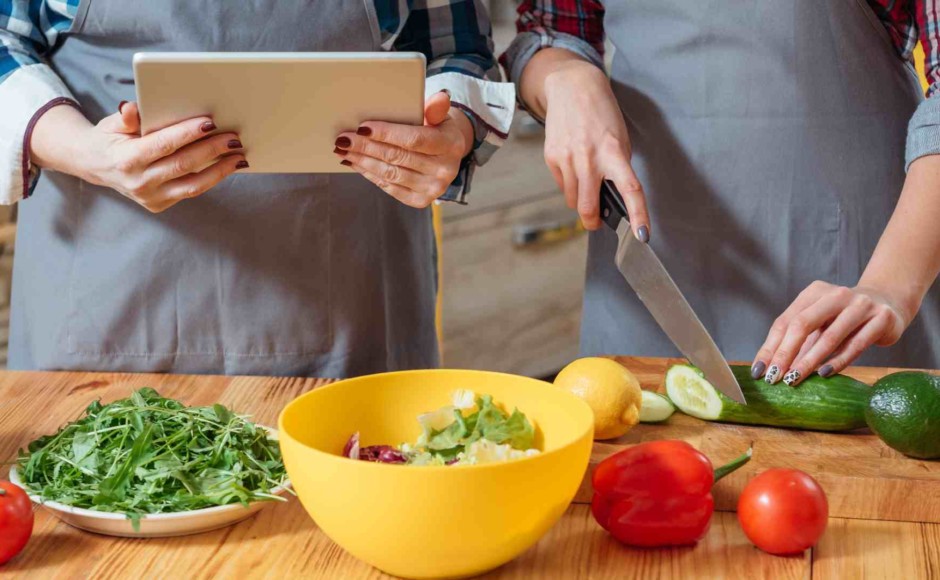 Pareja cocinando mientras toman un curso de Cocina Internacional