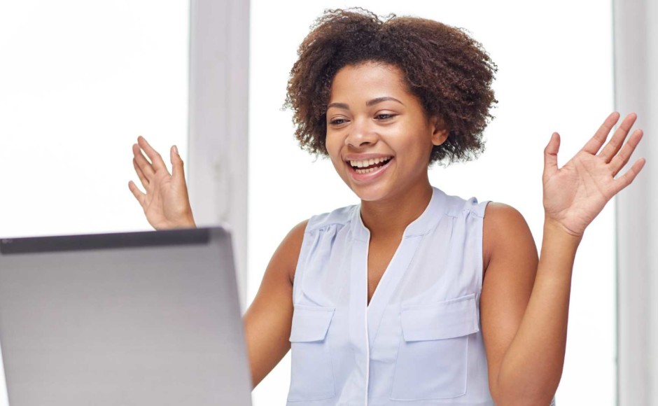 Mujer sentada frente a su computadora personal y sorprendida