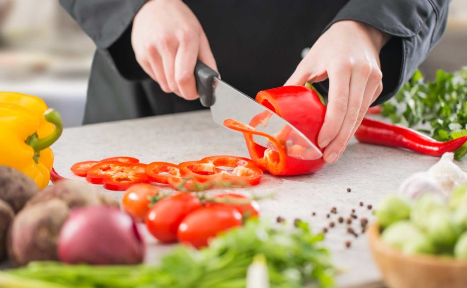 Manos de un hombre cortando verduras