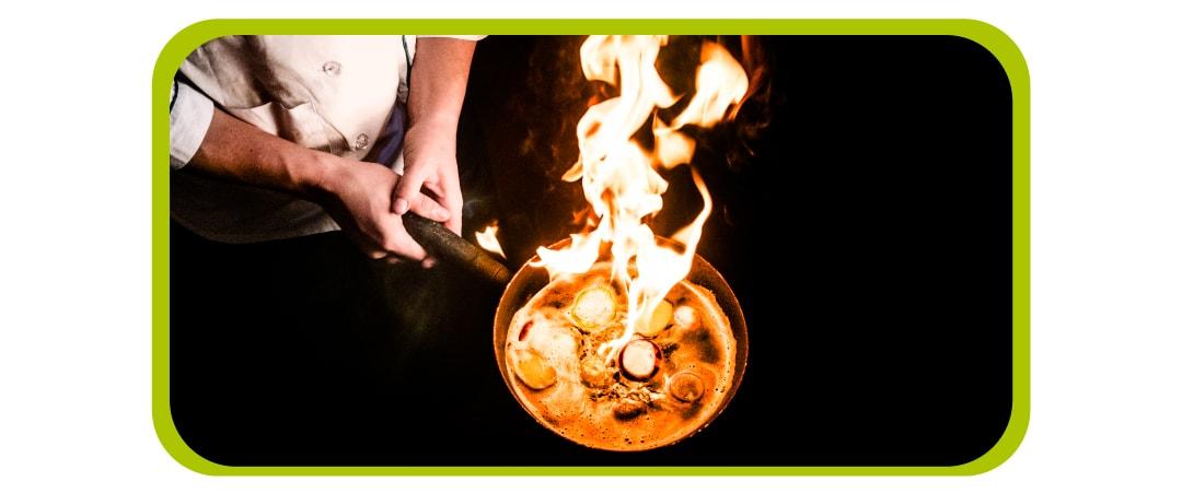 chef cocinando en un sartén los alimentos