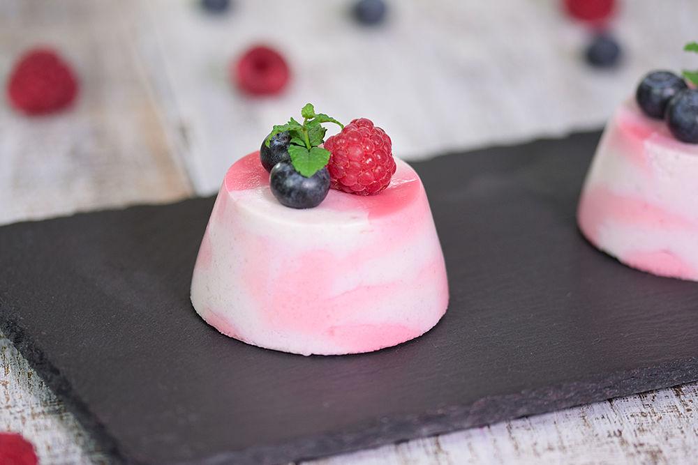 mousse sobre una tabla con frambuesas y moras sobre ella