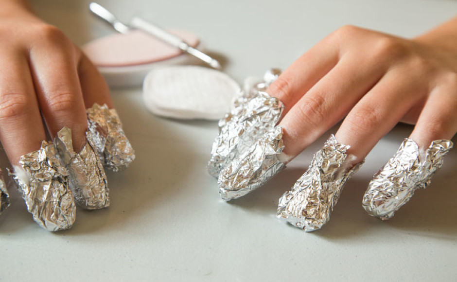 dedos de la mano con papel aluminio para remover las uñas con acetona