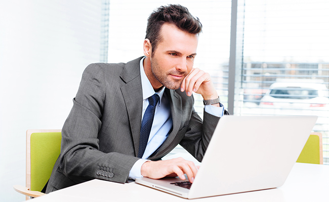 hombre de traje trabajando frente a una computadora