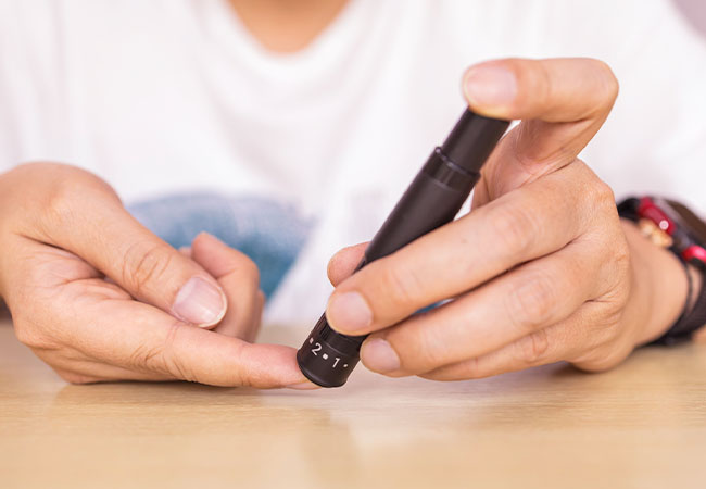 diabetico pinchando su dedo para medir insulina