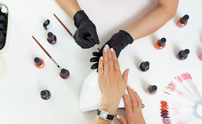 manicura pintando las uñas con colores extravagantes