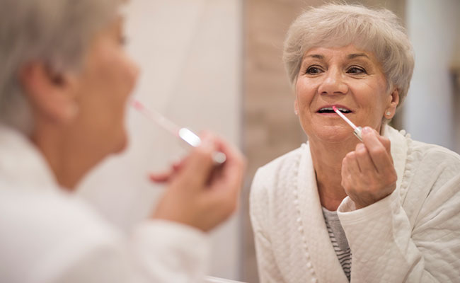 Mujer mayor de 60 retocándose su labial