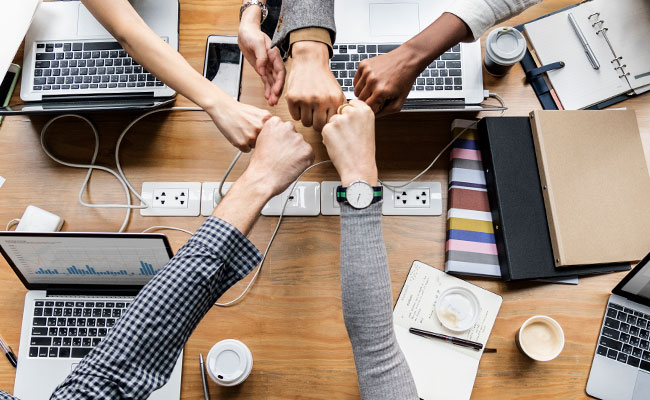 equipo de trabajo chocando los puños en señal de celebración o victoria