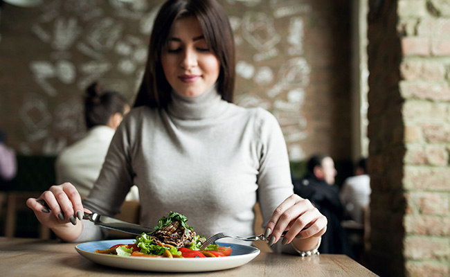 mujer frente a su plato de comida