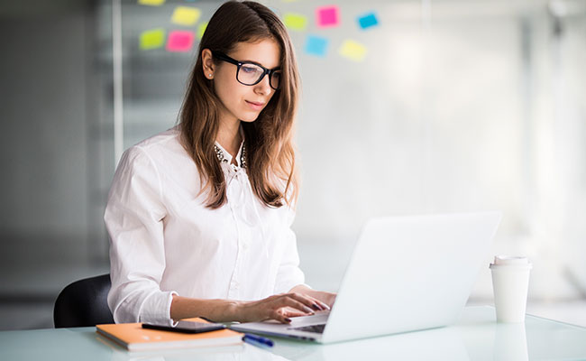 persona trabajando en una computadora y leyendo sobre las ventajas de crear una llc en usa