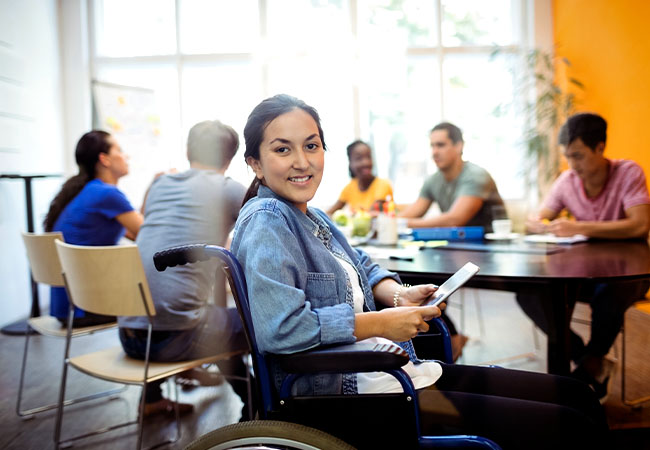 persona con discapacidad conversando con un equipo de trabajo