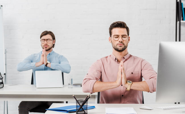 dos personas meditando en el trabajo