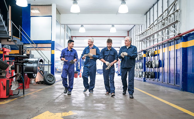 Equipo de trabajo de mecánicos charlando sobre el trabajo a realizar