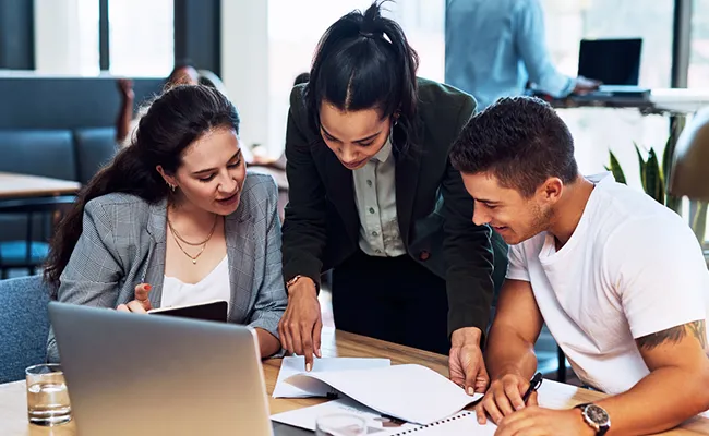 equipo de trabajo dialogando en una mesa de la oficina