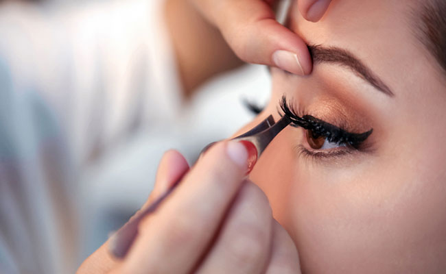 maquilladora colocando pestañas postizas a una clienta