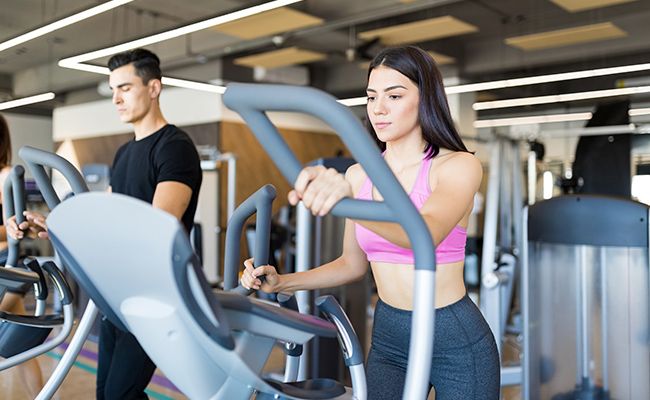 mujer joven en el gimnasio corriendo en la cinta