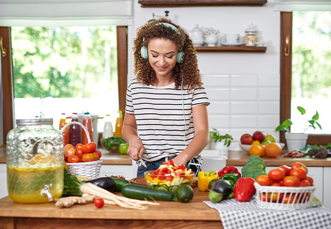 mujer preparando alimentos y verduras en su cocina