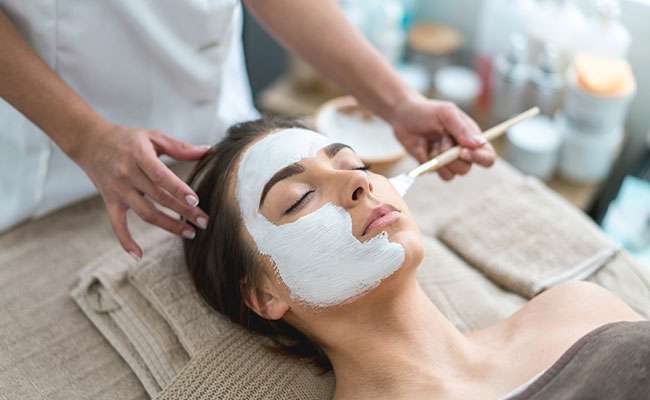 persona realizando limpieza facial en spa