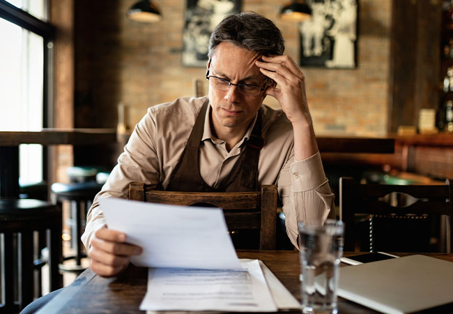 emprendedor evaluando y analizando en su escritorio con papeles en su mano