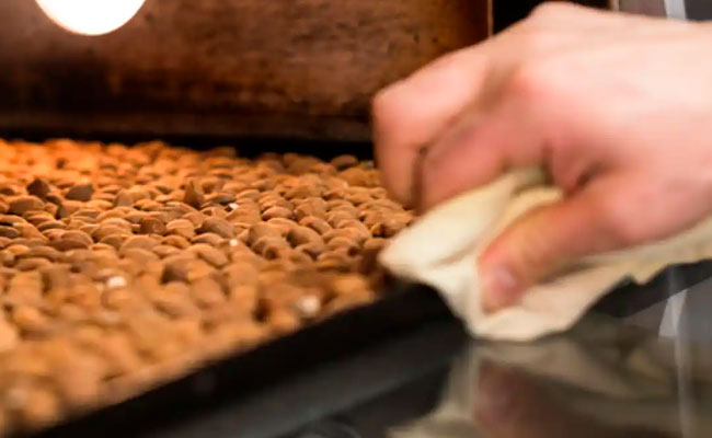 hombre sacando almendras del horno