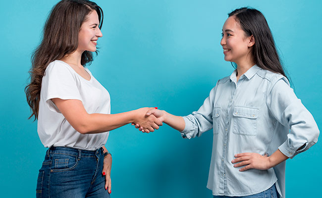 mujer tomando de la mano a otra con una sonrisa