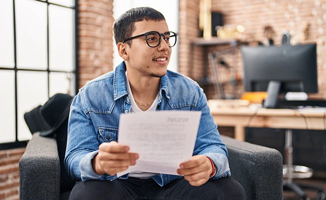 joven latino entregando su cv a un empleador