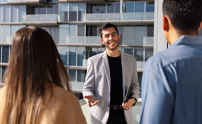 broker de real estate latino atendiendo a dos clientes